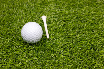 Golf ball is on green grass with tee