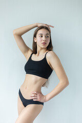 Fototapeta premium Natural beauty brunette model no make up in swimsuit posing in studio on isolated background. Model tests, natural no make up models concept