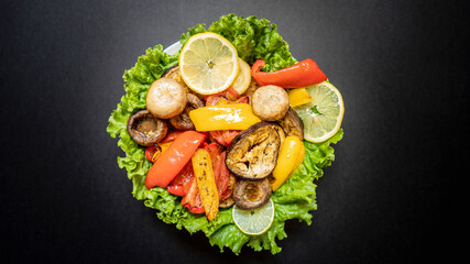 Healthy eating. Grilled vegetables on a plate decorated with salad leaves. View from above