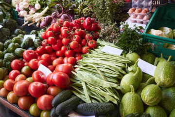 Stand with vegetables on the farmers market - tomatoes, cucumbers and pea pods. Funchal, Madeira, Portugal.