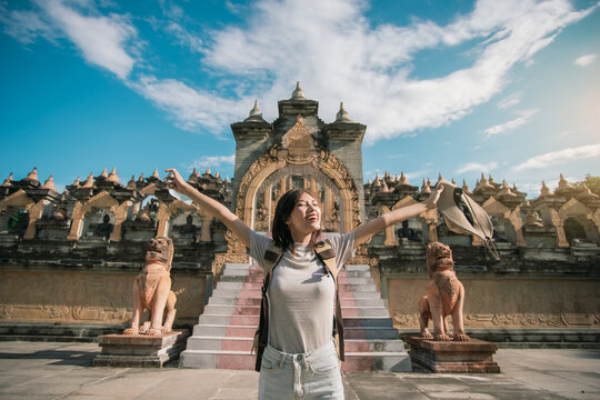 Asian woman traveler happy cheerful tourism with pagoda of buddhist temple in background. Travel Southeast Asia culture. Pagoda of Buddhist in Thailand.