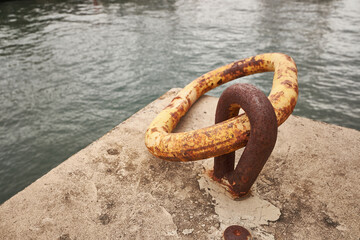 Rusty chain for boat anchor on pier. Closeup photo, taken in Funchal, Madeira, Portugal.