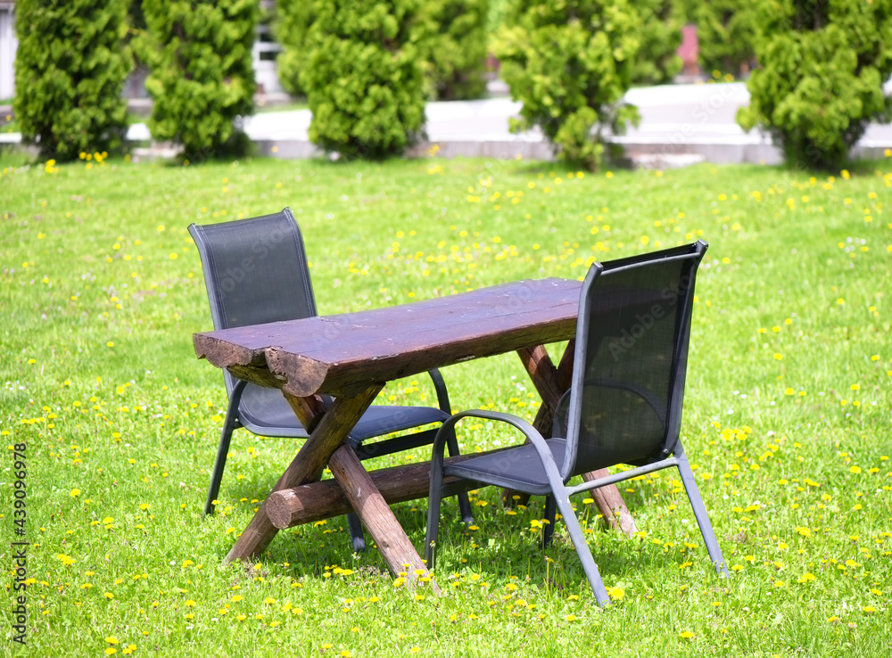 Wall mural two chairs and wooden table outdoors in nature