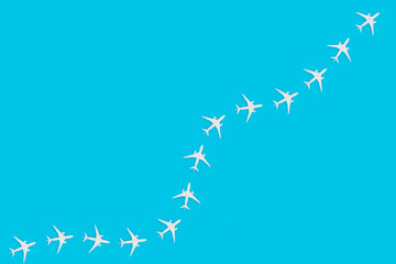 Simple traveling concept with toy airplanes on pastel blue background.