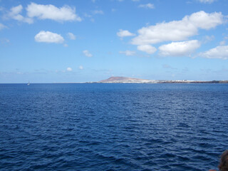 View from the Fred Olsen Canary Island Ferry to the flat land of Playa Blanca Lanzarote with a mountain in the haze of heat