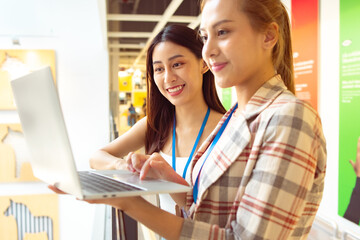 Portrait of Asian Woman Smiling Charmingly while Standing in walkway office. Portrait Of Successful Business Woman with laptop,startup small business concept in modern office.