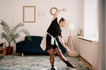 Teenager girl practicing ballet online classes at home. Woman dancing indoors