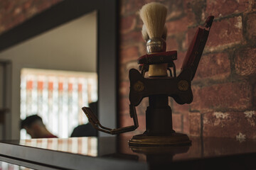 Shaving brush on a mini hairdressing chair in a vintage barbershop