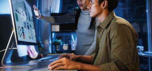 Young Asian business man and woman work late night together on desktop computer with team in home office. Project brainstorm meeting, Small business startup, coworker cooperate teamwork concept