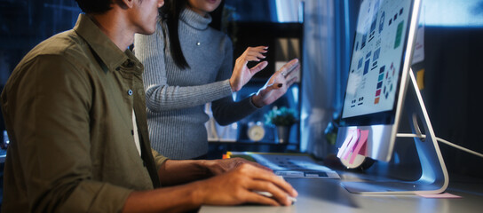 Young Asian business man and woman work late night together on desktop computer with team in home office. Project brainstorm meeting, Small business startup, coworker cooperate teamwork concept