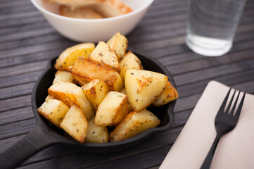 Spanish traditional appetizer patatas bravas on small cast iron skillet