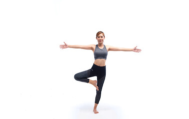 Fototapeta na wymiar Young woman in grey sport wears doing yoga on leg in studio white background. Concept of home exercise. Yoga time at home.