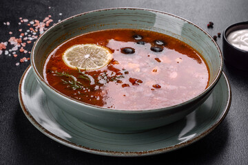 Delicious fresh hot soup with tomato and meat in a ceramic plate. Hodgepodge soup