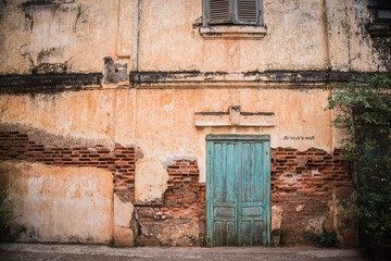 Fototapeta na wymiar Wall of an old building with a blue door in Savannakhet, Laos