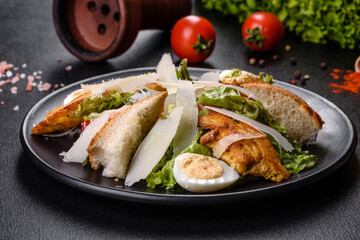 Delicious fresh caesar salad with chicken meat, breadcrumbs, tomatoes and lettuce leaves