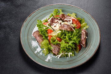 Delicious fresh salad with beef, cheese, tomatoes and lettuce leaves