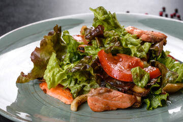 Delicious fresh salad with fish, cheese, tomatoes and lettuce leaves
