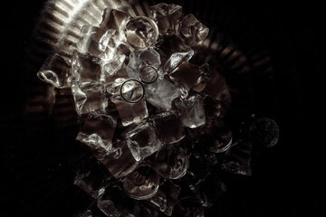 Wedding rings on a platter with ice. Wedding details for the ceremony.
Black and white photo.