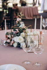 Champagne glasses. Candles and flowers. Banquet table decoration.