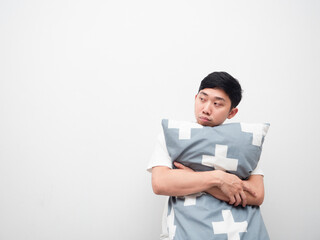 Asian man hug pillow feeling sleepy look at space white background