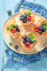 Homemade phyllo cups made of cream and beries. Summer snack.