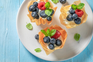 Delicious phyllo cups made of cream and beries. Summer snack.