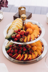 Dishes with berries and exotic fruits. Fruit salad. Dessert on the festive table.