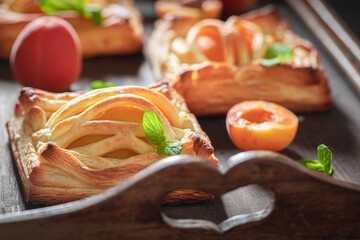 Tasty puff pastry with peaches and mint. Unique yummy cake.