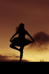 Silhouette of young ballerina dancing and having fun outdoors