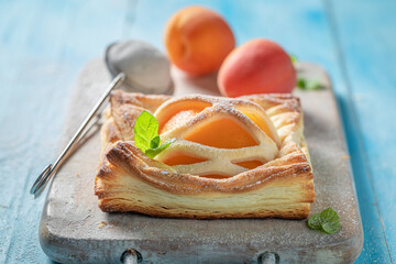 Delicious puff pastry with sugar and peaches. Unique yummy cake. - obrazy, fototapety, plakaty