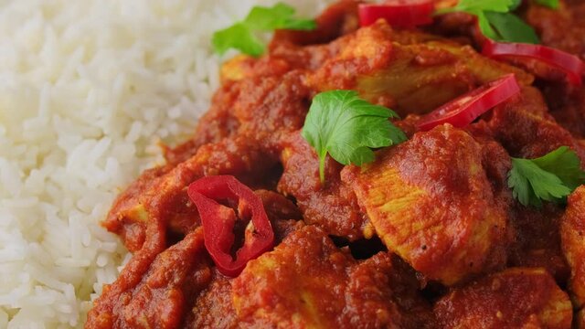 Spicy Chicken Pathia curry with basmati rice in a white plate. healthy food. rotating video