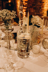 Champagne glasses. Candles and flowers. Banquet table decoration.