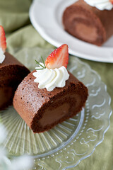 Chocolate Swiss Roll Cake with Chocolate cream filling and Strawberry set on cafe table.