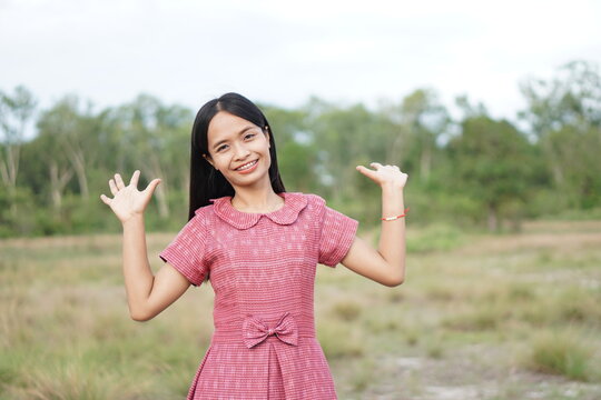 Asian woman smiling happily raise your hand to the sky nature background