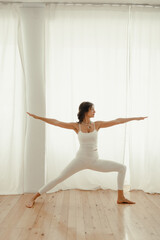 Beautiful woman practicing yoga at home. woman in the morning doing yoga in the bedroom. Bright bedroom. healthy lifestyle