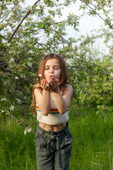 Fototapeta premium Happy girl enjoying sunny day in the park among blossom trees