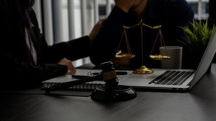 The judge's hammer was placed in front of him. and lawyers cheering clients in the office with laptops and scales of justice.