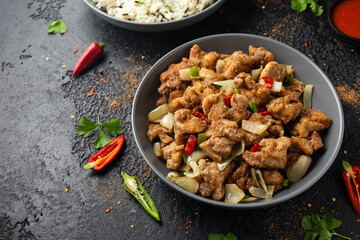 Stir fry chinese salt and pepper chicken with rice in grey bowl