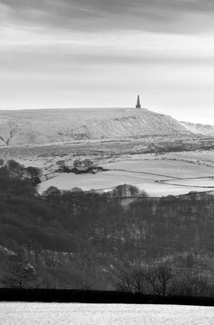 snow covered fields with stoodley pike monument and moors in the distance in calderdale west yorkshire
