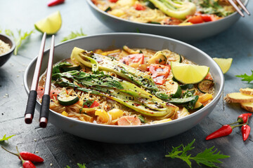 Asian style Pak choi, lemongrass, and ginger curried noodles served with lime wedges