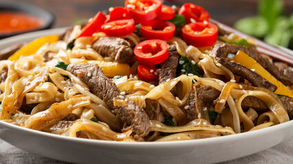 Stir fry Beef Chow Fun with rice noodles, bean sprouts, spring onions and chili.