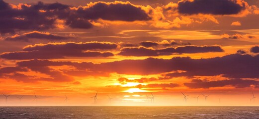 Renewable green electricity wind power generation offshore. Sunrise at decarbonization industry...