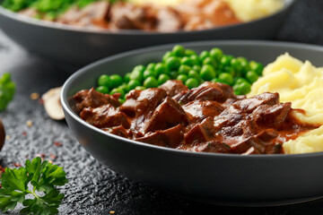 Slow Cooked Steak Diane Casserole with mushroom. mashed potatoes and green peas