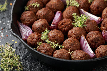 Thyme and onion vegetarian vegan meatballs oven baked in cast iron skillet frying pan