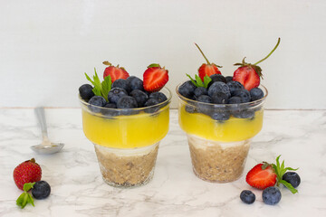 Homemade lemon cheesecake with blueberries
 and strawberry isolated on light grey background. Ketogenic diet. Healthy dessert. Still life photography.	