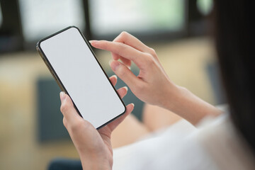 Cropped shot of professional businesswoman holding blank screen smartphone in a modern office room.