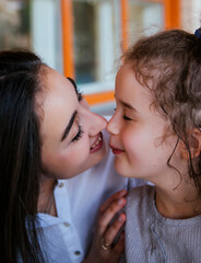 Naklejka premium A young mother embraces her little daughter.A gentle mother's kiss. Mother's Day and March 8.