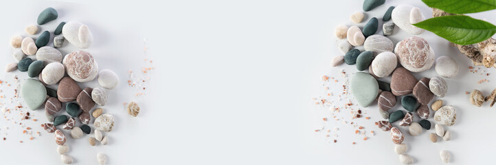 banner, spa relax, stack of round colored stones, sea salt, body peeling cream, avocado leaves on white background, empty space for text in the middle