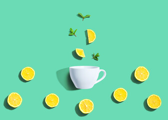 Fresh yellow lemons with tea cup overhead view