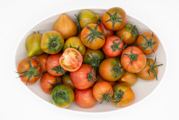 Fresh cherry tomato in a white plate with a top view.